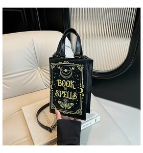 Detail of black Book of Spells bag with golden moon and star prints on white stand
