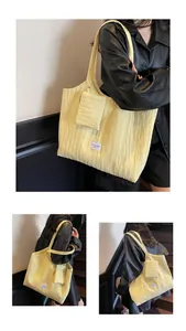 Détail du sac cabas en toile jaune froissée avec pochette assortie et étiquette