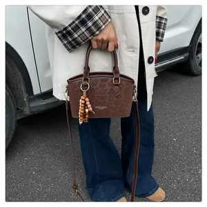 Détail d'un sac à main léopard avec texture cuir et pendentif en perles de bois