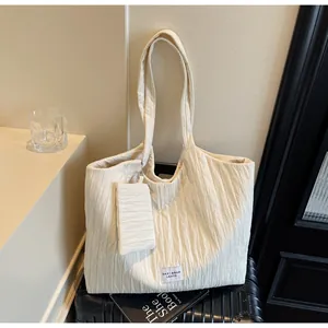 Détail du grand cabas en toile plissée blanc cassé avec une petite pochette assortie