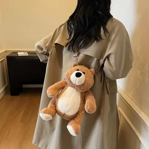 Cute brown plush teddy bear crossbody bag with leather straps worn by a person