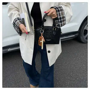 Détail du sac bandoulière léopard noir avec pendentif perlé et garnitures dorées