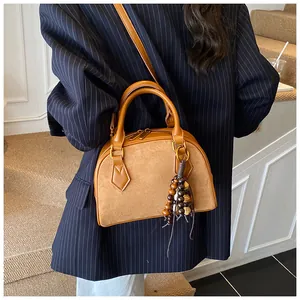 Detailed view of a vintage caramel shell bag featuring suede and smooth leather texture