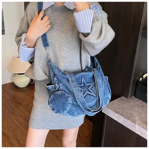 Detail of blue denim tote bag featuring star stitching and round coin purse attachment