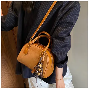 Detail of vintage brown shell bag with smooth leather and suede patchwork finish
