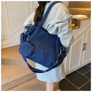 Detail of blue denim tote bag with star pattern embossing and small round purse