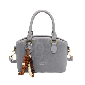 Sac à main gris motif léopard avec pendentif en perles de bois et bandoulière longue