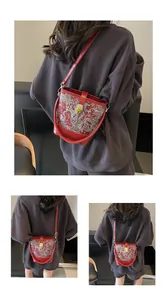 Detail of red Chinese style bucket bag with silver embroidery and metal twist lock