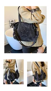 Detail of black denim tote bag with star embossed pattern and side coin purse