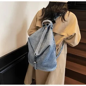 Vue arrière d'un mannequin portant le sac à dos en jean vintage sur un escalier
