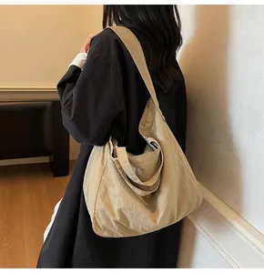 Spacious khaki canvas tote bag worn over the shoulder showing soft drape and large capacity