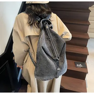 Vue détaillée du sac à dos en jean délavé vintage avec fermeture éclair verticale