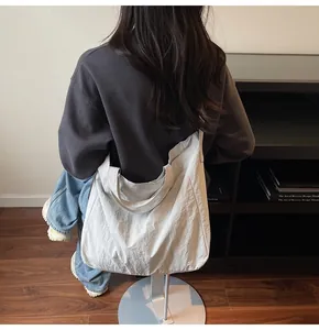 Side view of large cream canvas tote bag showing lightweight fabric and wide shoulder strap
