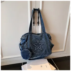 Detail of blue denim tote bag featuring embossed star design and detachable coin purse