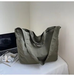 Detail of army green large canvas tote bag with dual straps on desk with laptop