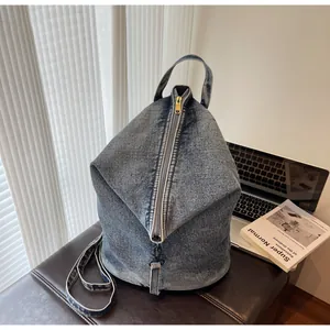 Détail du sac en jean délavé bleu avec fermeture éclair en métal sur un banc en cuir