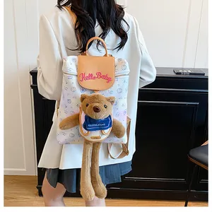 Detail of cute plush bear and pink Hello Baby embroidery on stylish lady backpack