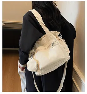 Detail of off-white canvas tote bag featuring front zipper pocket and round coin purse