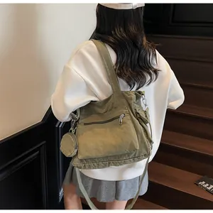 Green canvas tote bag with a front zipper pocket and a matching small round coin purse