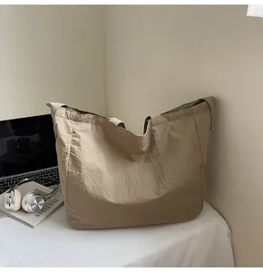 Detailed scene of a khaki canvas tote bag on a table with a laptop and headphones