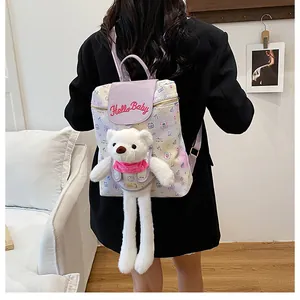 Detail of cartoon backpack featuring purple flap, Hello Baby embroidery and bear plush charm