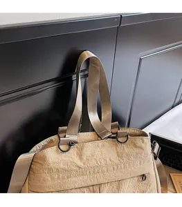 Detail of adjustable nylon strap and metal D-ring on beige lightweight tote bag