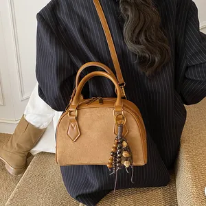 Vintage brown leather shell bag with wooden bead fringe and adjustable shoulder strap