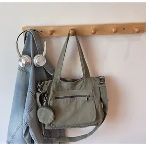 Detail of army green canvas tote bag with small round pouch and adjustable strap