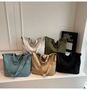 Group display of five colorful nylon tote bags with pleated textures and adjustable straps
