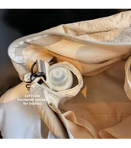Detail view of the insulated side pocket for baby bottles inside the beige tote bag