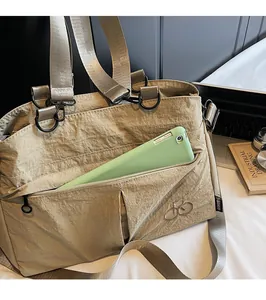Detail showing the large capacity front zipper pocket of the khaki casual tote bag