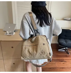 Détail du sac cabas en nylon kaki avec bandoulière réglable dans un cadre de vie réel