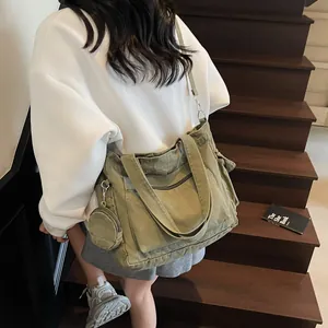 Olive green large canvas tote bag with mini pouch shown on shoulder in a casual style
