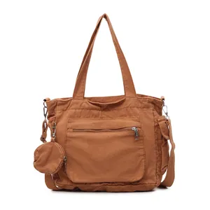 Brown canvas tote bag with wide shoulder strap and matching round coin purse on white background