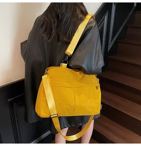 Détail d'un sac cabas en nylon jaune avec sangle réglable et étiquette de marque