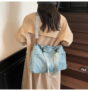 Photo lifestyle d'une femme portant un grand sac cabas bleu clair avec bandoulière