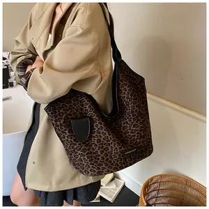 Détail du sac cabas léopard avec étiquette de logo en cuir et sangle noire chic