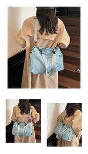 Détail du sac cabas en nylon bleu clair avec logo brodé et bandoulière sur mannequin