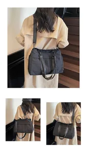 Gros plan du sac fourre-tout en nylon noir avec logo SHUNUO et sangle réglable