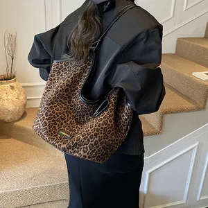 Grand sac cabas léopard à la mode avec finitions en cuir noir porté par un modèle