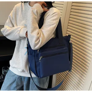 Deep blue nylon tote bag detail with double front zipper pockets for daily organization