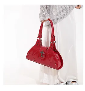 Detail of red wax leather tote featuring Gothic metal cross and punk rivet studs
