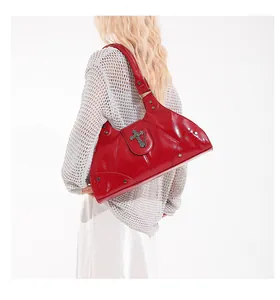 Close-up of vintage red hobo bag with embossed silver cross buckle and rivet accents