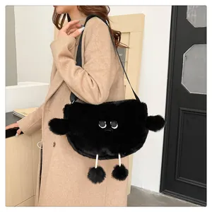 Dettaglio della borsa a tracolla in peluche nera con ricamo stravagante e pompon carini