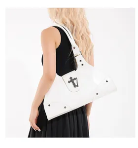 Detail of white vintage oil-wax leather tote with metallic gothic cross and silver rivets