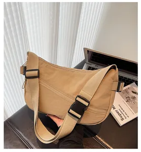 Detail of khaki nylon crescent bag with adjustable wide strap and black plastic buckle
