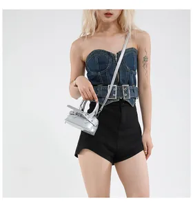 Chic silver metallic mini handbag paired with denim corset and black shorts in studio shot