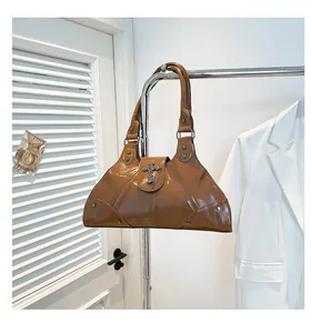Detail of brown oil wax leather tote with silver rivets and vintage cross pendant decoration