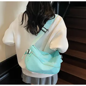 Close-up of mint green nylon crossbody bag showing adjustable strap and front zipper pocket