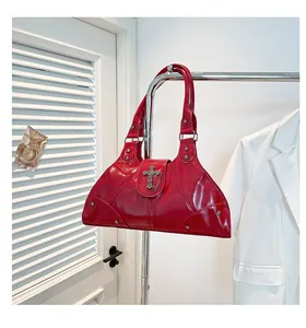 Detail of red wax leather tote bag with silver cross pendant and metal rivet accents